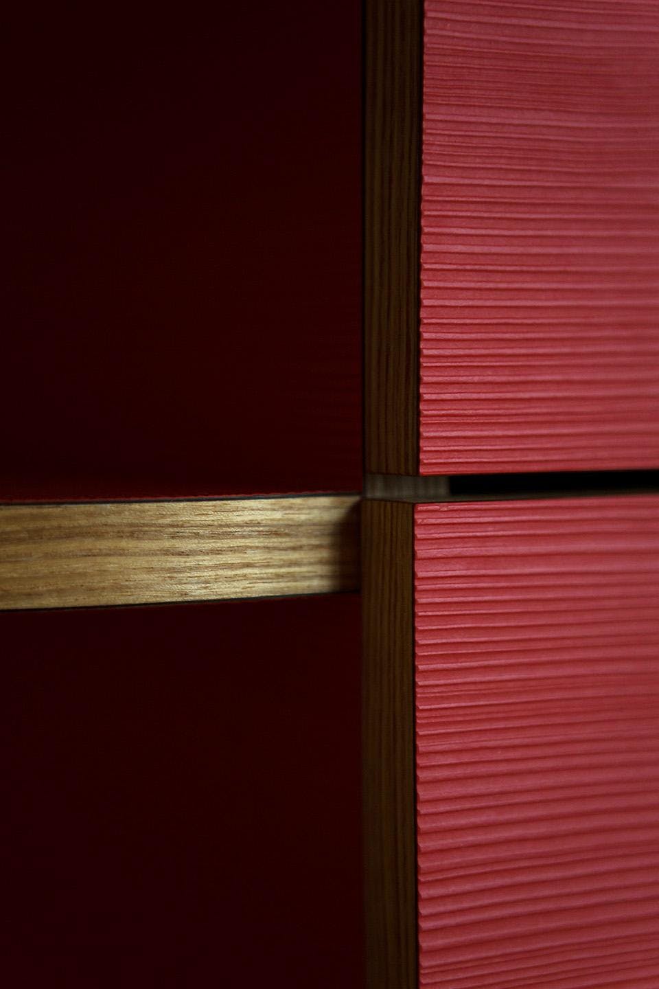 The image features a red wall with a wooden frame, which is the focal point of the scene. The wall is painted in a vibrant red color, creating a striking contrast with the wooden frame. The wooden frame is made of wood and appears to be part of the wall's design.

The wall is not particularly tall, but it is quite wide, stretching from the top left corner to the bottom right corner of the image. The wooden frame is positioned in the middle of the wall, adding depth and interest to the scene.
