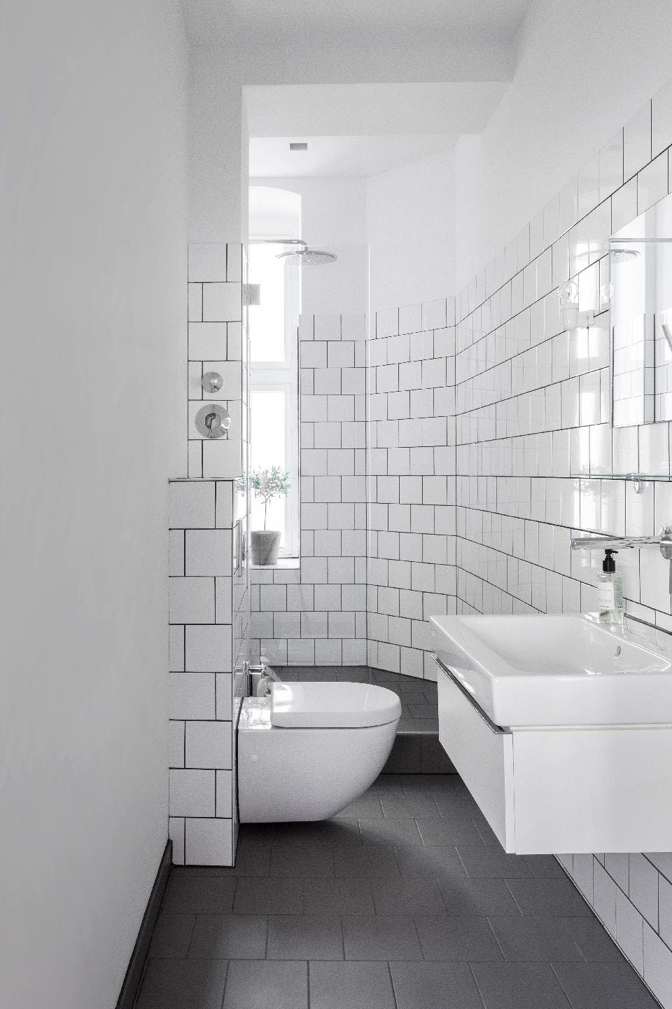 The image features a modern bathroom with a white sink, toilet, and bathtub.