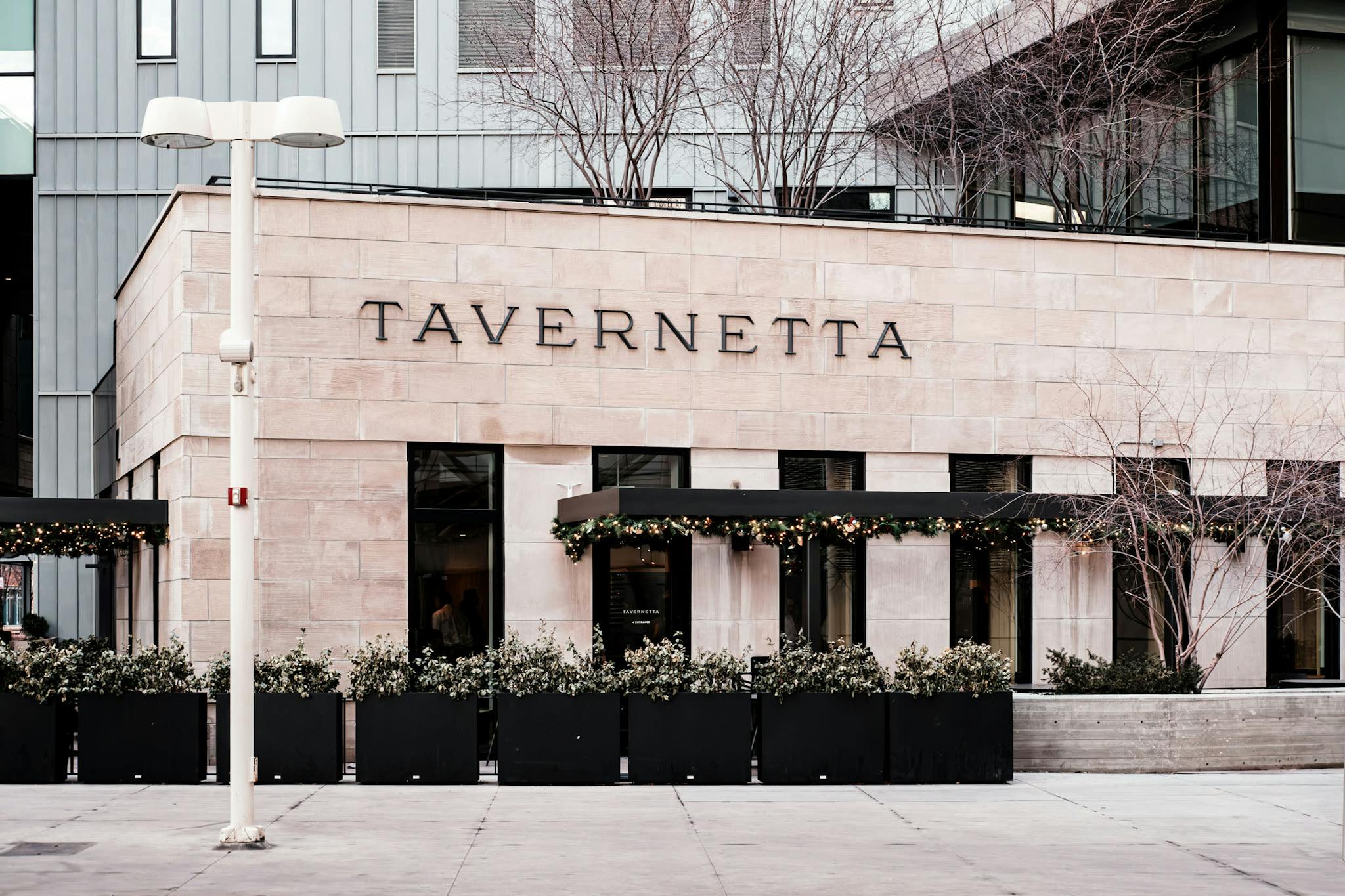 a tall building with a sign that says tavernetteta on the side of it's side walk