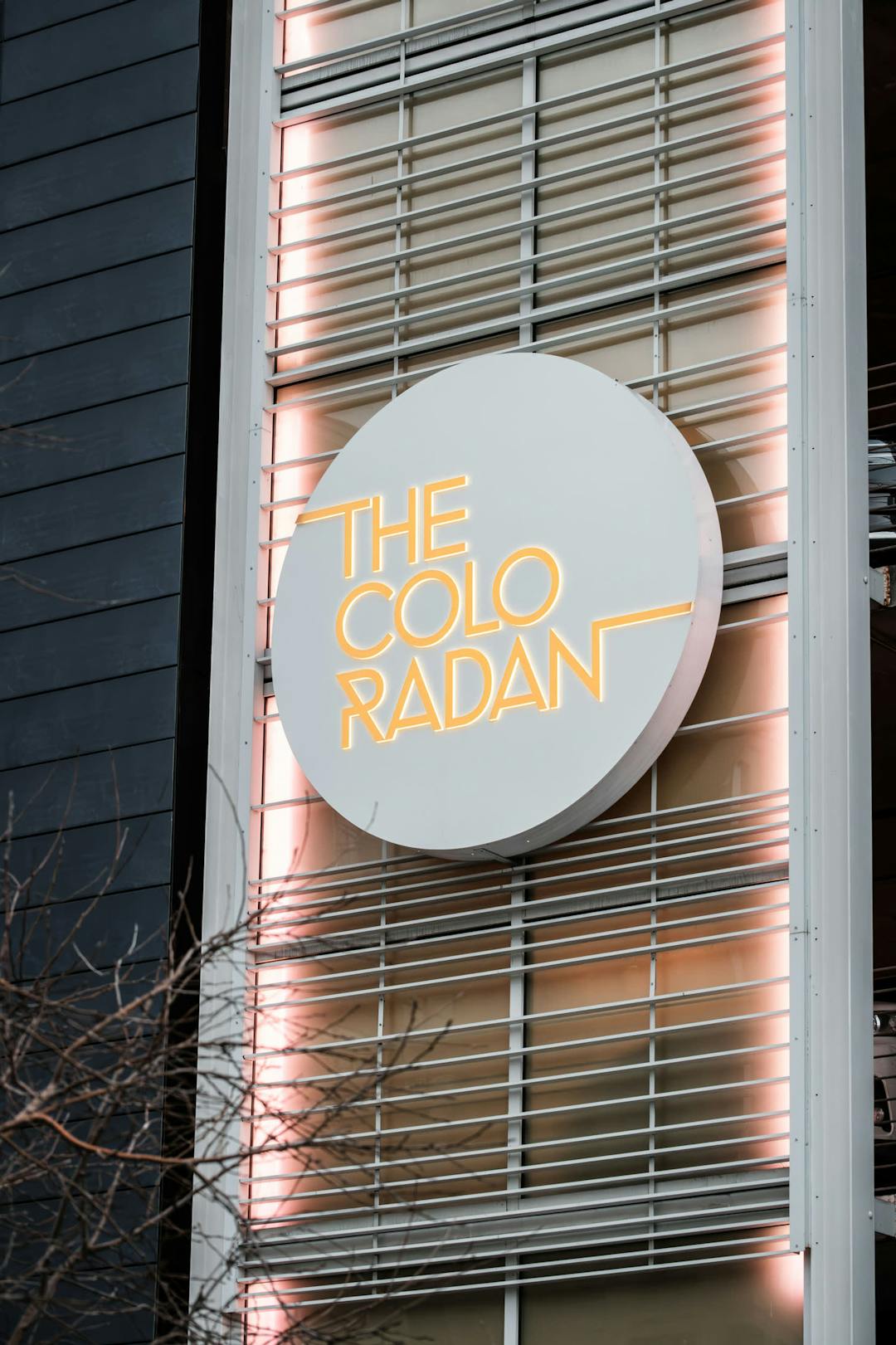 a neon sign on the side of a building that says the colo radant on the side of the building